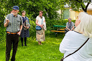 Stadtführer Robert Forster (links im Bild) erzählt beim Rundgang von Garten, Gebäude und Geschichte des Schafhofs. (Foto: Schafhof Freising) 