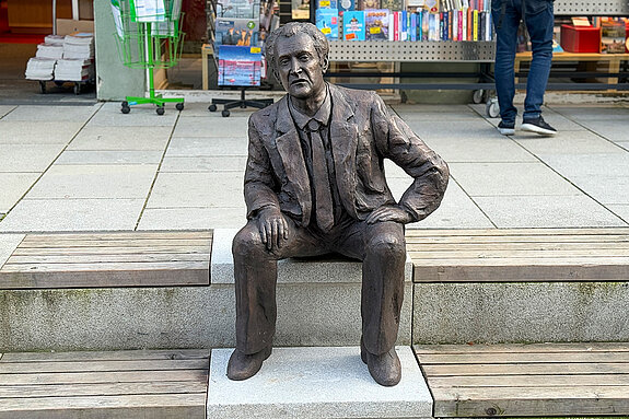 Kal Obermayr has taken a seat on the steps of Moosach in Obere Hauptstraße - why don't you join him?