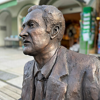 Kal Obermayr has taken a seat on the steps of Moosach in Obere Hauptstraße - why don't you join him?