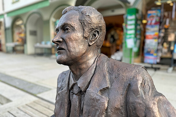 Kal Obermayr has taken a seat on the steps of Moosach in Obere Hauptstraße - why don't you join him?
